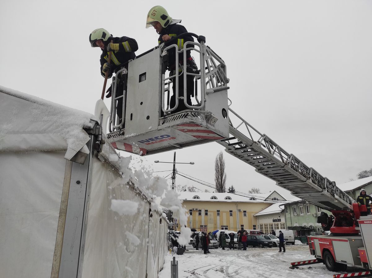 A tűzoltók takarítják le a havat a tetőről